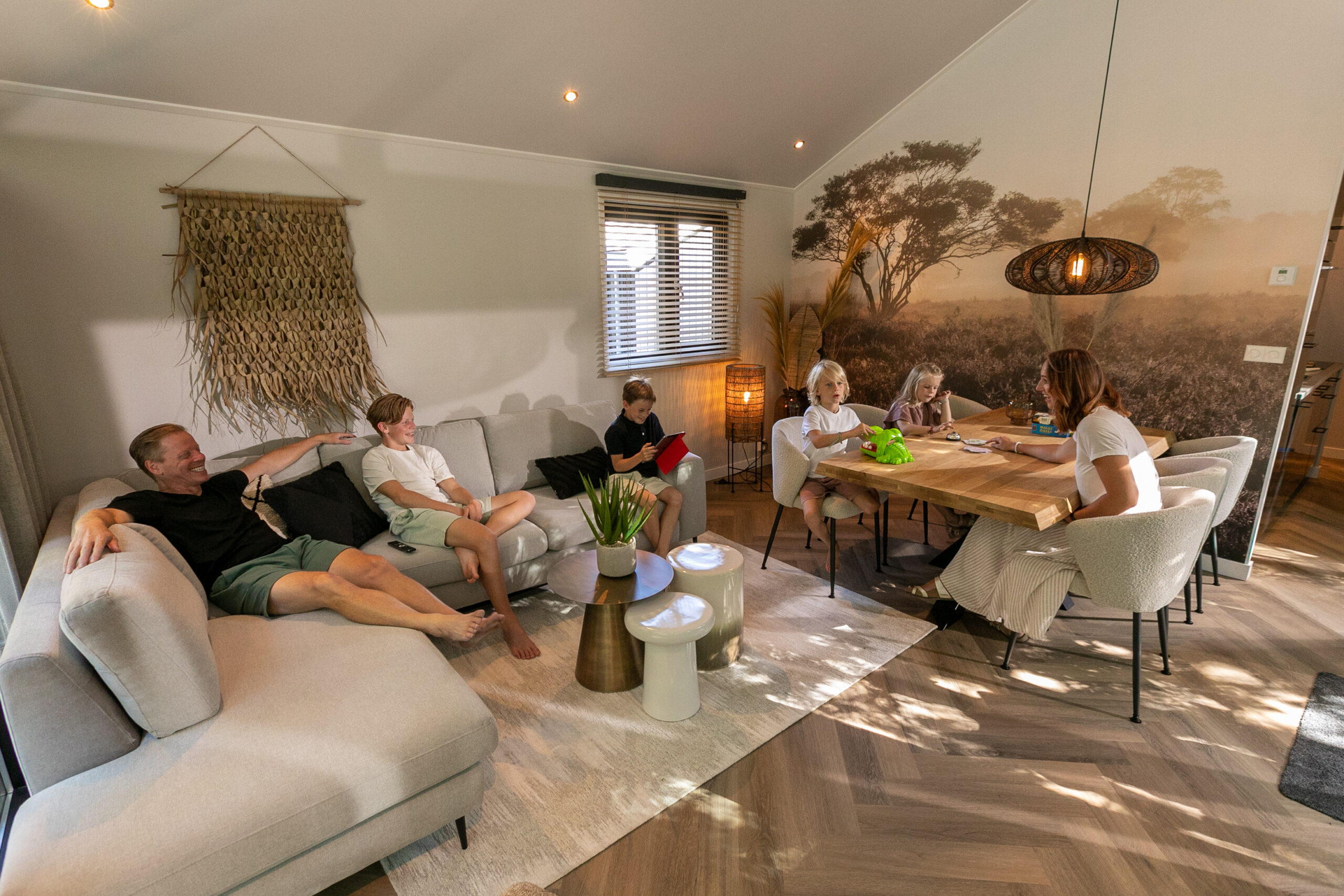 Gezin samen in een chalet Gezin geniet samen in de woonkamer van een sfeervol chalet.
